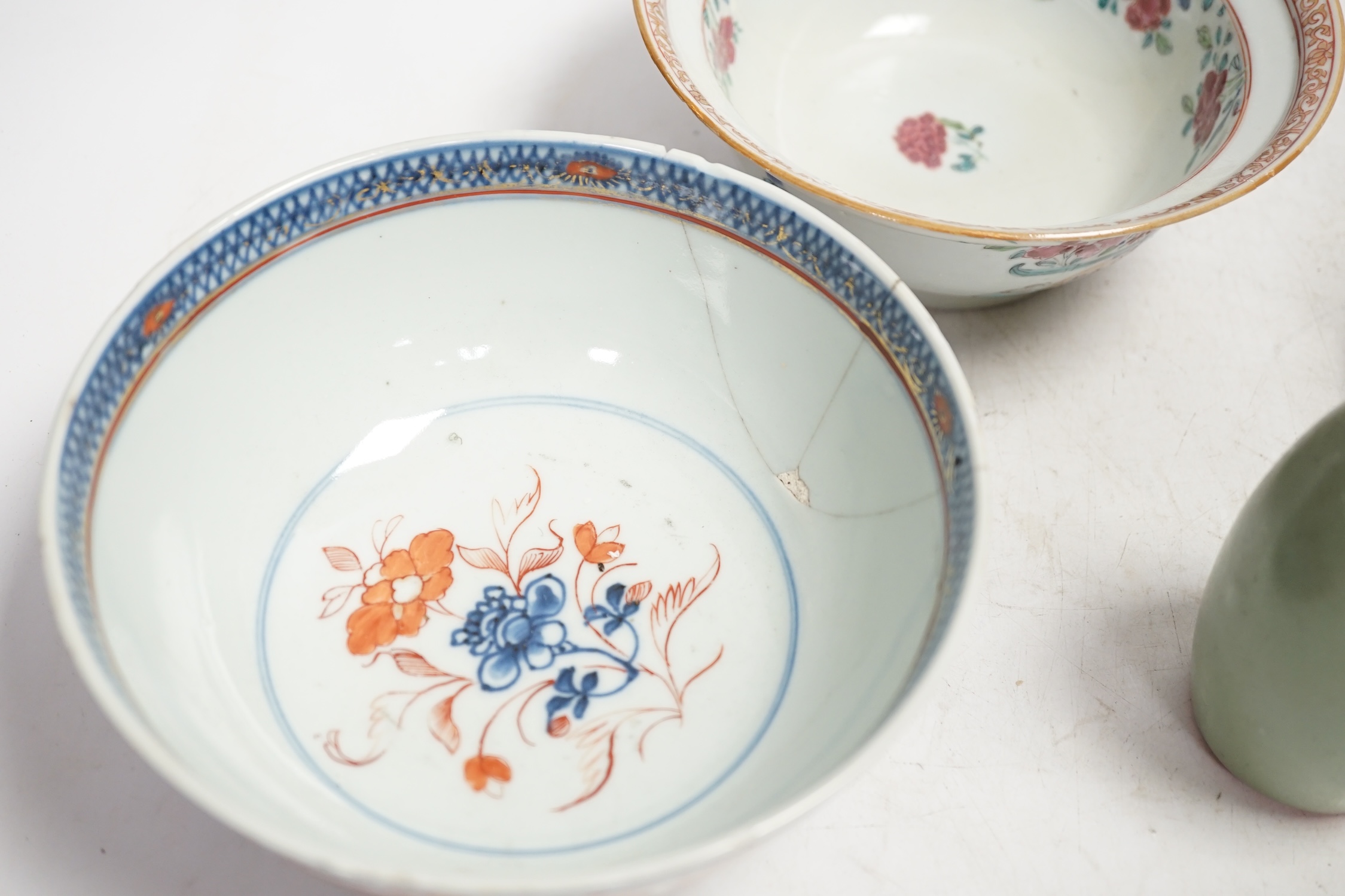 A Chinese famille rose bowl, an Imari patterned bowl, a small blue glazed vase and a similar celadon glazed vase, 18th century and later. Condition - both bowls badly cracked, overall poor